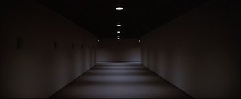Movie still from “Westworld” (1973), directed by Michael Crichton – A dark hallway with a light shining on the wall; Extreme Wide shot, High angle
