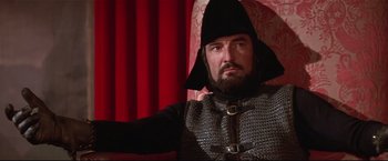 Movie still from “Westworld” (1973), directed by Michael Crichton – A man wearing a black hat and a chain - mail outfit; Medium shot, Low angle