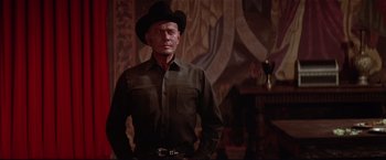 Movie still from “Westworld” (1973), directed by Michael Crichton – A man wearing a cowboy hat standing in front of a painting; Medium shot, Low angle
