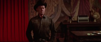 Movie still from “Westworld” (1973), directed by Michael Crichton – A man wearing a cowboy hat standing in front of a painting; Medium shot, Low angle