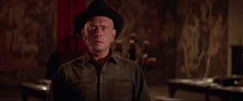 Movie still from “Westworld” (1973), directed by Michael Crichton – An old man wearing a black hat and a brown shirt; Close Up shot, Low angle