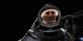Movie still from “Another Life” (2019), created by Aaron Martin – A man in a spacesuit is looking into a mirror; Close Up shot, Overhead angle