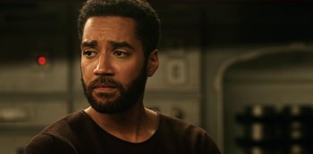 Movie still from “Another Life” (2019), created by Aaron Martin – A person with a beard looking to his left; Close Up shot, Over the shoulder angle