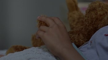 Movie still from “Westworld” (2016), created by Lisa Joy – A child's hand holding a stuffed animal while sitting on a blanket; Close Up shot, Overhead angle