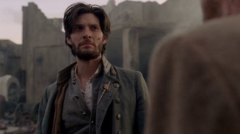 Movie still from “Westworld” (2016), created by Lisa Joy – A man with a long beard standing in front of a wall; Close Up shot, Over the shoulder angle