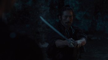 Movie still from “Westworld” (2016), created by Lisa Joy – A man holding a sword in a dark forest; Medium shot, Low angle