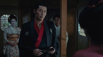 Movie still from “Westworld” (2016), created by Lisa Joy – A man wearing a black robe and a red tie; Medium shot, Over the shoulder angle