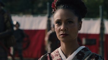 Movie still from “Westworld” (2016), created by Lisa Joy – A woman in a kimono is standing in front of a flag; Close Up shot, Over the shoulder angle