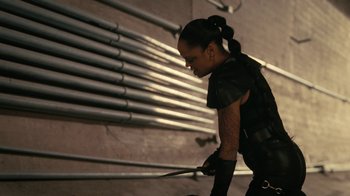 Movie still from “Westworld” (2016), created by Lisa Joy – A woman holding a pair of scissors while standing in a room; Medium shot, Low angle