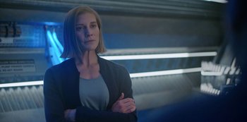 Movie still from “Another Life” (2019), created by Aaron Martin – A woman standing with her arms crossed in front of a wall; Close Up shot, Over the shoulder angle