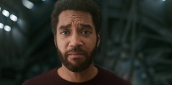 Movie still from “Another Life” (2019), created by Aaron Martin – A person with a beard looking at the camera; Close Up shot, Low angle