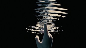 Movie still from “Westworld” (2016), created by Lisa Joy – A hand touching a water surface with its fingers; Extreme Close Up shot, Overhead angle