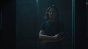 A woman holding a cell phone while standing in a dark room