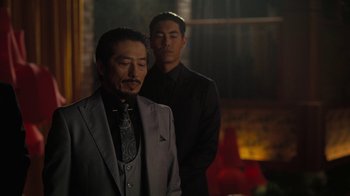 Movie still from “Westworld” (2016), created by Lisa Joy – Two men in suits standing next to each other in a dark room; Medium shot, Over the shoulder angle