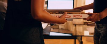 Movie still from “Wetlands” (2013), directed by David Wnendt – A person holding a box of pizza in their hand; Extreme Close Up shot, High angle