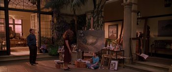 Movie still from “What Dreams May Come” (1998), directed by Vincent Ward – A woman standing next to a man in front of an easel; Wide shot, High angle