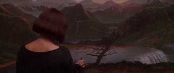 Movie still from “What Dreams May Come” (1998), directed by Vincent Ward – A woman standing in front of a painting of mountains; Medium shot, Over the shoulder angle