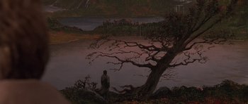 Movie still from “What Dreams May Come” (1998), directed by Vincent Ward – A man standing next to a tree near a body of water; Extreme Wide shot, High angle