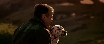 Movie still from “What Dreams May Come” (1998), directed by Vincent Ward – A man holding a dalmatian dog in his arms; Close Up shot, Over the shoulder angle