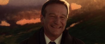 Movie still from “What Dreams May Come” (1998), directed by Vincent Ward – A man in a suit and tie smiling for the camera; Close Up shot, Low angle