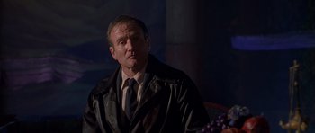 Movie still from “What Dreams May Come” (1998), directed by Vincent Ward – A man wearing a black jacket and a tie; Medium shot, Over the shoulder angle