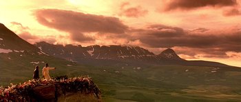 Movie still from “What Dreams May Come” (1998), directed by Vincent Ward – A view of a mountain range from a hill side; Extreme Wide shot, Low angle