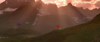 Movie still from “What Dreams May Come” (1998), directed by Vincent Ward – A person holding a red flag on top of a hill; Extreme Wide shot, Low angle