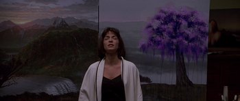 Movie still from “What Dreams May Come” (1998), directed by Vincent Ward – A woman standing in front of a painting of trees; Medium shot, Low angle