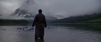 Movie still from “What Dreams May Come” (1998), directed by Vincent Ward – A man standing in the water in front of a body of water; Wide shot, Low angle