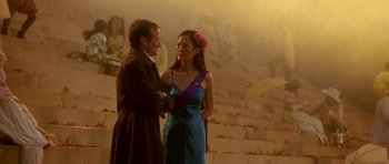 Movie still from “What Dreams May Come” (1998), directed by Vincent Ward – A man and a woman standing next to each other in front of an audience; Medium shot, Over the shoulder angle