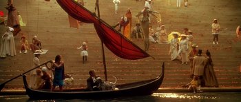 Movie still from “What Dreams May Come” (1998), directed by Vincent Ward – A man in a boat on a body of water; Wide shot, High angle
