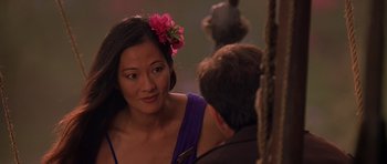 Movie still from “What Dreams May Come” (1998), directed by Vincent Ward – A woman wearing a flower in her hair talking to a man; Close Up shot, Over the shoulder angle