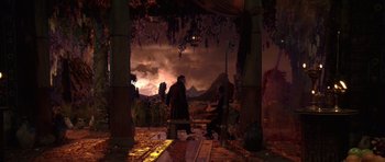 Movie still from “What Dreams May Come” (1998), directed by Vincent Ward – Two people sitting on a bench under a sky; Extreme Wide shot, High angle