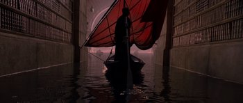 Movie still from “What Dreams May Come” (1998), directed by Vincent Ward – A man in a boat with a red sail in the middle of the water; Wide shot, Low angle