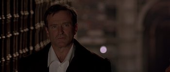 Movie still from “What Dreams May Come” (1998), directed by Vincent Ward – A person wearing a suit and tie; Close Up shot, Over the shoulder angle