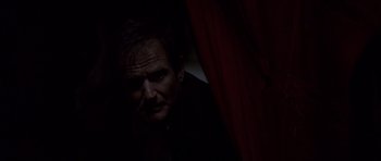 A man in a dark room looking at the camera