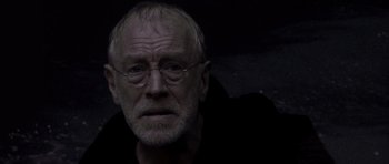 Movie still from “What Dreams May Come” (1998), directed by Vincent Ward – An older man with glasses is looking at the camera; Close Up shot, Low angle