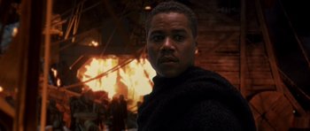 Movie still from “What Dreams May Come” (1998), directed by Vincent Ward – A man standing in front of a burning building; Close Up shot, Low angle