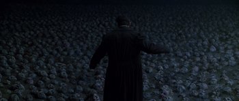 Movie still from “What Dreams May Come” (1998), directed by Vincent Ward – A man standing in front of a lot of masks; Wide shot, High angle