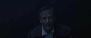 Movie still from “What Dreams May Come” (1998), directed by Vincent Ward – A man in a dark room with his mouth wide open; Close Up shot, Overhead angle