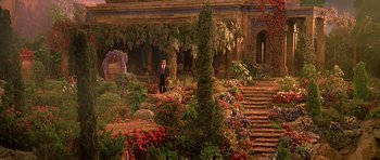 Movie still from “What Dreams May Come” (1998), directed by Vincent Ward – A man in a suit standing next to a garden; Extreme Wide shot, High angle
