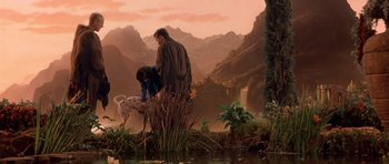 Movie still from “What Dreams May Come” (1998), directed by Vincent Ward – A man and a woman standing next to a dog; Wide shot, High angle
