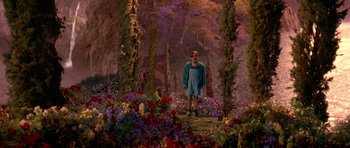 Movie still from “What Dreams May Come” (1998), directed by Vincent Ward – A man standing next to a forest filled with flowers; Wide shot, High angle