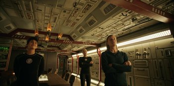 Movie still from “Another Life” (2019), created by Aaron Martin – Two women standing in a room with a table and chairs in front of them; Wide shot, Low angle