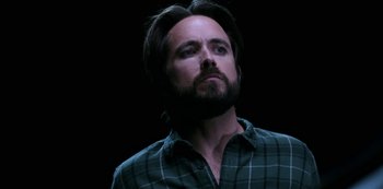 Movie still from “Another Life” (2019), created by Aaron Martin – A man with long hair and a beard looking upward; Close Up shot, Low angle