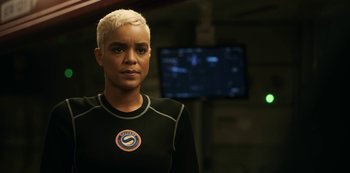 Movie still from “Another Life” (2019), created by Aaron Martin – A woman with blonde hair is wearing a black shirt; Close Up shot, Over the shoulder angle