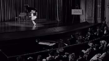Movie still from “What Ever Happened to Baby Jane?” (1962), directed by Robert Aldrich – A person performing on a stage in front of an audience; Extreme Wide shot, High angle