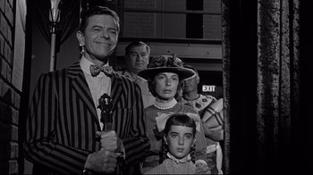 Movie still from “What Ever Happened to Baby Jane?” (1962), directed by Robert Aldrich – A group of people standing next to each other in front of an exit sign; Medium shot, Low angle