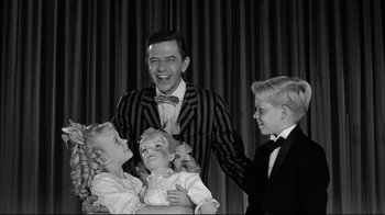 Movie still from “What Ever Happened to Baby Jane?” (1962), directed by Robert Aldrich – A black and white photo of a man and two boys; Medium shot, High angle