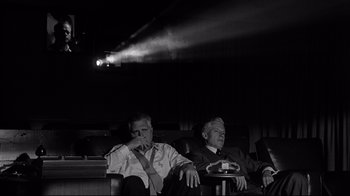 Movie still from “What Ever Happened to Baby Jane?” (1962), directed by Robert Aldrich – Two older men sitting in a movie theater watching a movie; Wide shot, Low angle